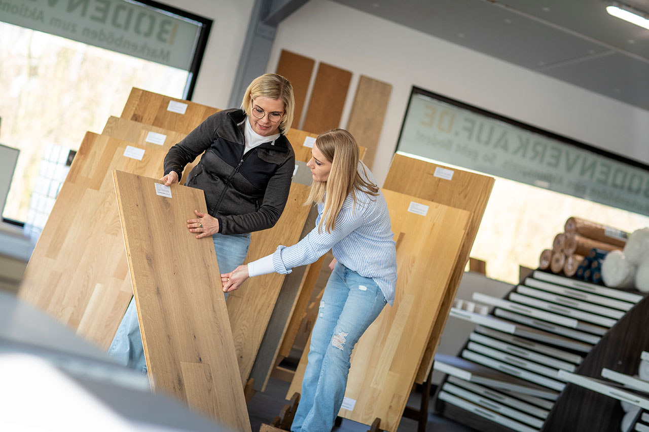Ein Kundin begutachtet einen Parkettboden im Lagerverkauf